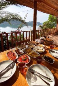 einen Tisch mit Lebensmittelplatten auf einem Tisch mit Aussicht in der Unterkunft Kekova Pansiyon in Demre