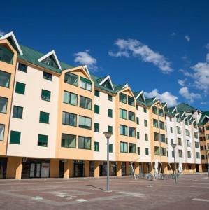 a large white building with a green roof at Sweet Apartments in Žabljak