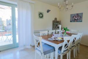 comedor con mesa blanca y sillas en Babér Cottage Vendégház Tihany en Tihany