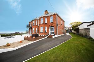 una gran casa de ladrillo rojo con un patio de hierba en No 10 Treverbyn Road, en Padstow