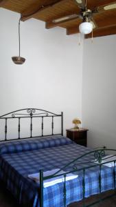 a bedroom with a bed with a blue blanket and a ceiling at Masseria Grande in Torre dell'Orso