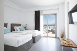 a hotel room with two beds and a balcony at Hermes&Dione in Argoulidhés