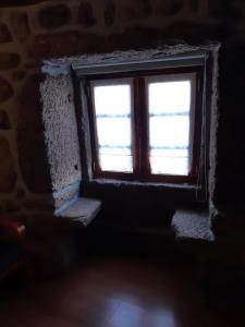 a window in a room with a stone wall at Caramulo - Abrigo Serrano in Carvalhal da Mulher