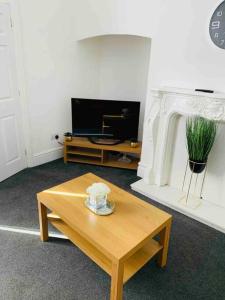 a living room with a coffee table and a fireplace at Blessed Roker home with free parking. in Monkwearmouth