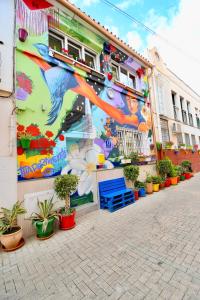 een muurschildering aan de zijkant van een gebouw met potplanten bij Jara Apartments ! in Málaga