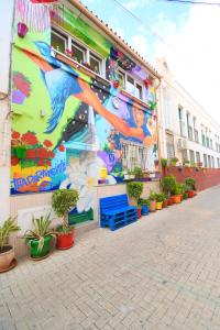 a mural on the side of a building with potted plants at Jara Apartments ! in Málaga