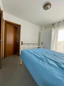 sypialnia z łóżkiem z niebieskim kocem w obiekcie Apartment, La Tejita. w mieście La Tejita