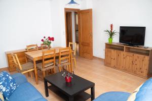 un soggiorno con divano, tavolo e TV di Casa Rural Villa de Yeste a Yeste