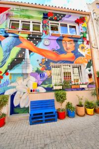 a mural on the side of a building with plants at Jara Apartments ! in Málaga