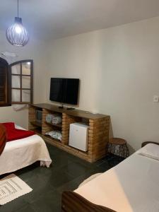 a room with a bed and a tv on a wall at Chales em Salesopolis - Recanto da Barra in Salesópolis