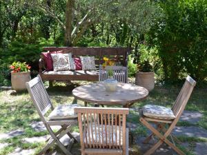 una mesa y dos sillas y un banco en un patio en La Devinière en Donzère