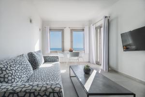 a living room with a couch and a tv at NiMa Sifnos Residences in Apollonia