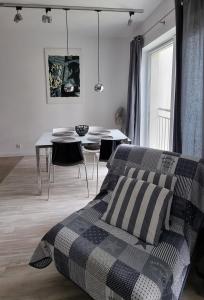1 dormitorio con 1 cama y 1 mesa con sillas en Stella Baltic 26, en Świnoujście