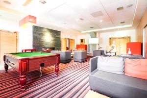 une salle de billard avec un billard et des canapés dans l'établissement 2 Bed Ski in and Ski out Luxury Apt in 5 star Residence, à Flaine