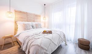 una camera bianca con un grande letto e una finestra di Apartament No 6 - HOME APART a Ostróda