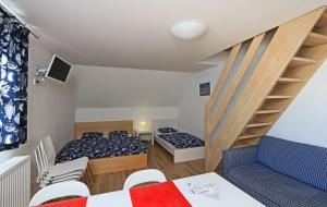 um pequeno quarto com 2 camas e uma escada em Apartmány Fox em Boží Dar