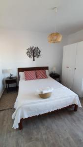 Un dormitorio con una cama blanca con una cesta. en CA NA CATALINA DEN ANDREU, en Sant Francesc Xavier