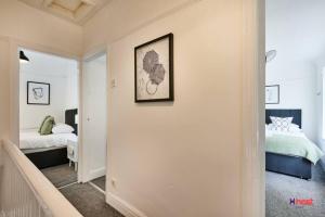 a hallway leading to a bedroom with a bed at Host Liverpool - Family Home Near Centre, Pets OK & Free Parking in Liverpool
