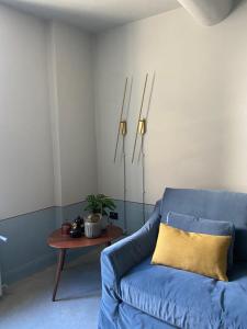 a living room with a blue couch and a table at Maison B in Mantova