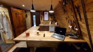 a laptop computer sitting on a wooden table in a kitchen at RESET W WERLASIE- Domek na wyłączność- kajak w cenie in Werlas