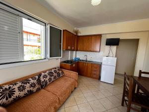 una sala de estar con sofá en una cocina con ventana en Fane's Apartments, en Himare