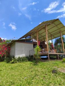 a house with a pavilion on a grass field at Hacienda Monteclaro in Turrialba