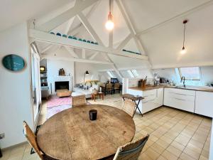 een keuken en een woonkamer met een houten tafel in een kamer bij COC - Villa Le Grand Terrain - Vue Mer in Wissant