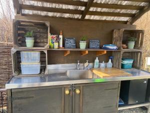 an outdoor kitchen with a sink and shelves at Belan Bluebell Woods Shepherds Hut in Llanidloes