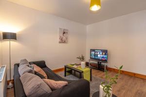 a living room with a couch and a tv at Beautiful 4 bedrooms house, 7 walk to train station in Plumstead