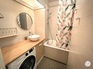 W łazience znajduje się pralka i umywalka. w obiekcie Au85, Bel appartement, vue océan, pied de la plage w mieście Saint-Jean-de-Monts