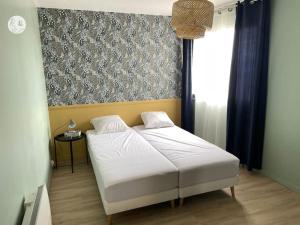 a bedroom with a white bed and a window at Au85, Bel appartement, vue océan, pied de la plage in Saint-Jean-de-Monts