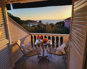 a table on a balcony with a view of the ocean at Silba Belvedere (2) 45m from the beach in Silba