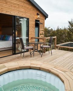 una terraza con mesa y sillas junto a una piscina en Bleu Hills Glamping Llanogrande, en Rionegro