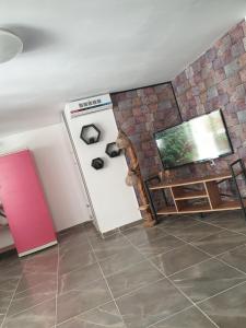 ein Wohnzimmer mit einem Kühlschrank und einem TV in der Unterkunft Schöne Unterkunft im Grünen mit privater Pool und Meeresblick in Kusadası