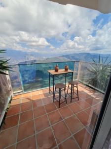 a table and two chairs on a balcony with a view at Parque Mirador del Chicamocha in Los Santos