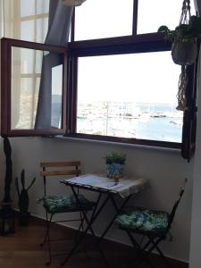 een tafel en 2 stoelen in een kamer met een raam bij Sa Calla Manna in Portoscuso