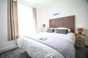 a bedroom with a large bed with a large window at No 10 Treverbyn Road in Padstow