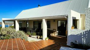 Casa blanca con techo y patio en Villa Paulina, en Langebaan