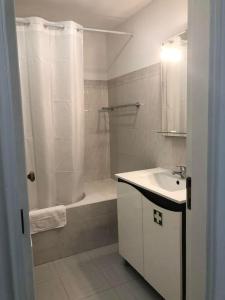 a bathroom with a shower and a sink and a tub at Bmar in Quarteira
