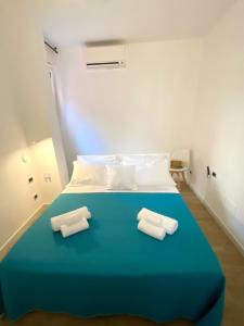 niebieskie łóżko z dwoma ręcznikami na górze w obiekcie Maison Bisou w Sorrento +8 zdjęć