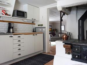 eine Küche mit einem Herd und ein Wohnzimmer in der Unterkunft Holiday home ÅTVIDABERG V in Sturefors