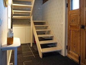 Una escalera de madera en una habitación junto a una puerta en Holiday home ÅTVIDABERG V en Sturefors