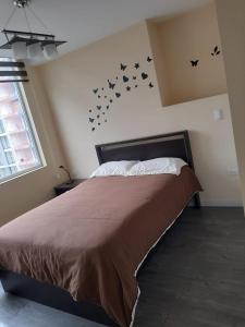 a bedroom with a bed with bats on the wall at EDIFICIO Samsara in Quito