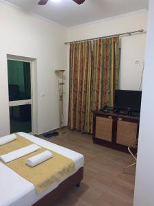 地拉那的住宿－HOTEL ARANDI AG，酒店客房设有两张床和电视。