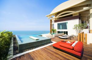 a living room filled with furniture and a pool at Centara Grand Mirage Beach Resort Pattaya - SHA Extra Plus in North Pattaya
