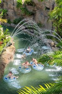 a group of people riding on tubes in a water slide at Centara Grand Mirage Beach Resort Pattaya in North Pattaya