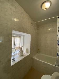bagno con vasca, finestra e lavandino di Casa Hortiñas a Chancelas