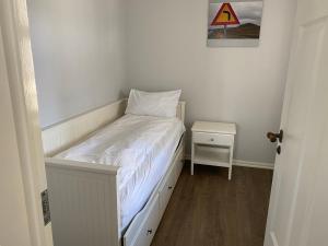 a small bedroom with a bed and a side table at Day Dream Soleyjargata Rooms & Apartments in Reykjavík