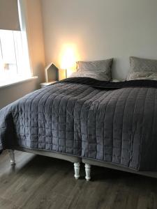 a bedroom with a large bed with a gray comforter at Day Dream Soleyjargata Rooms & Apartments in Reykjavík