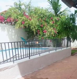 a fence with pink flowers and a blue bird on it at Appartement haut standing avec piscine in Yaoundé